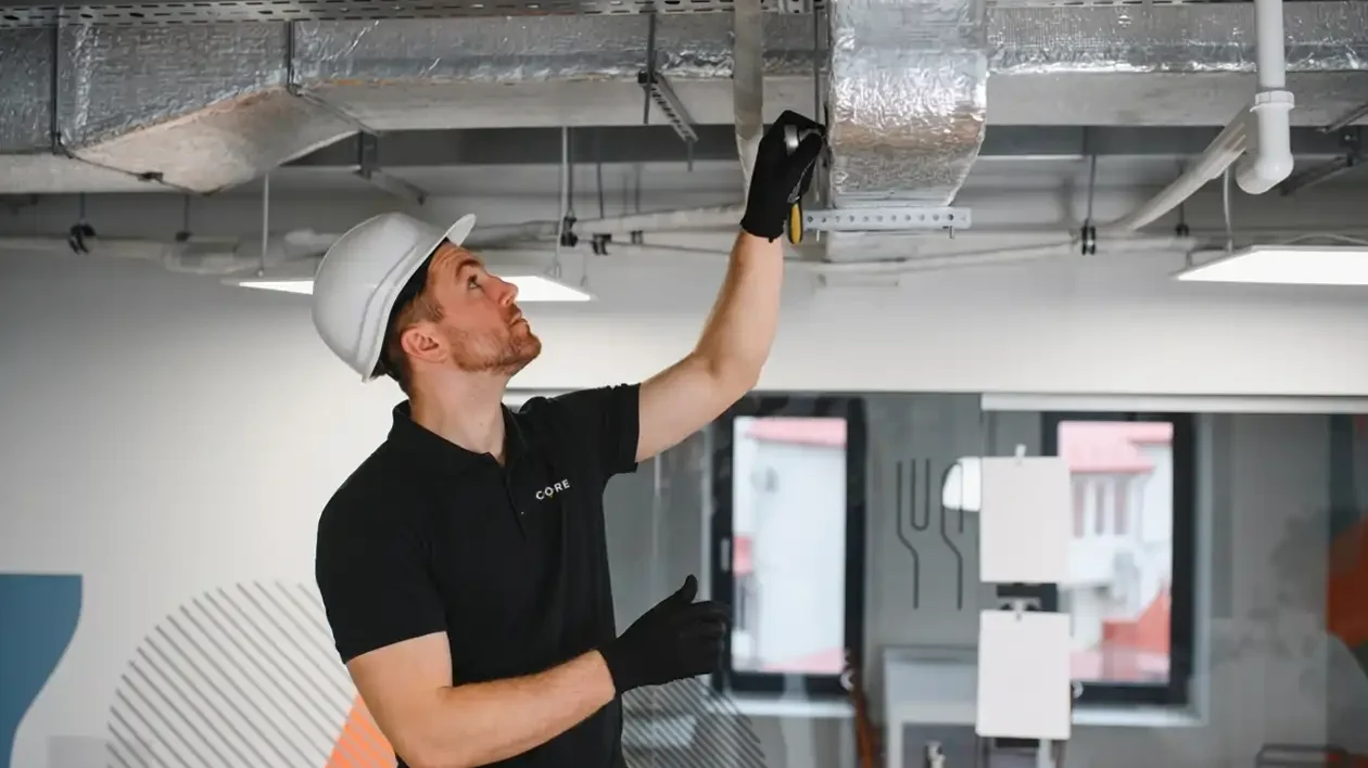 CORE Maintenance engineer inspecting cooling ductwork under a service agreement